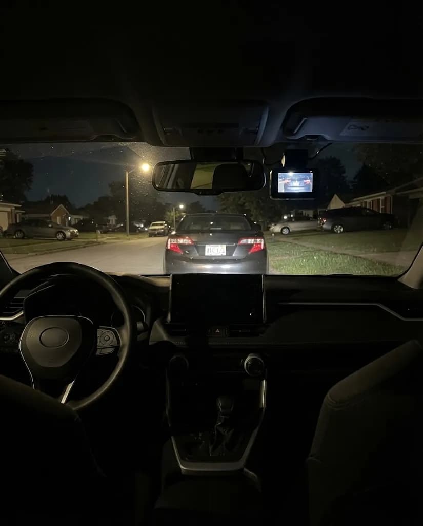 A wet street at night through the windshield, the Halden Duo 4K behind the mirror
